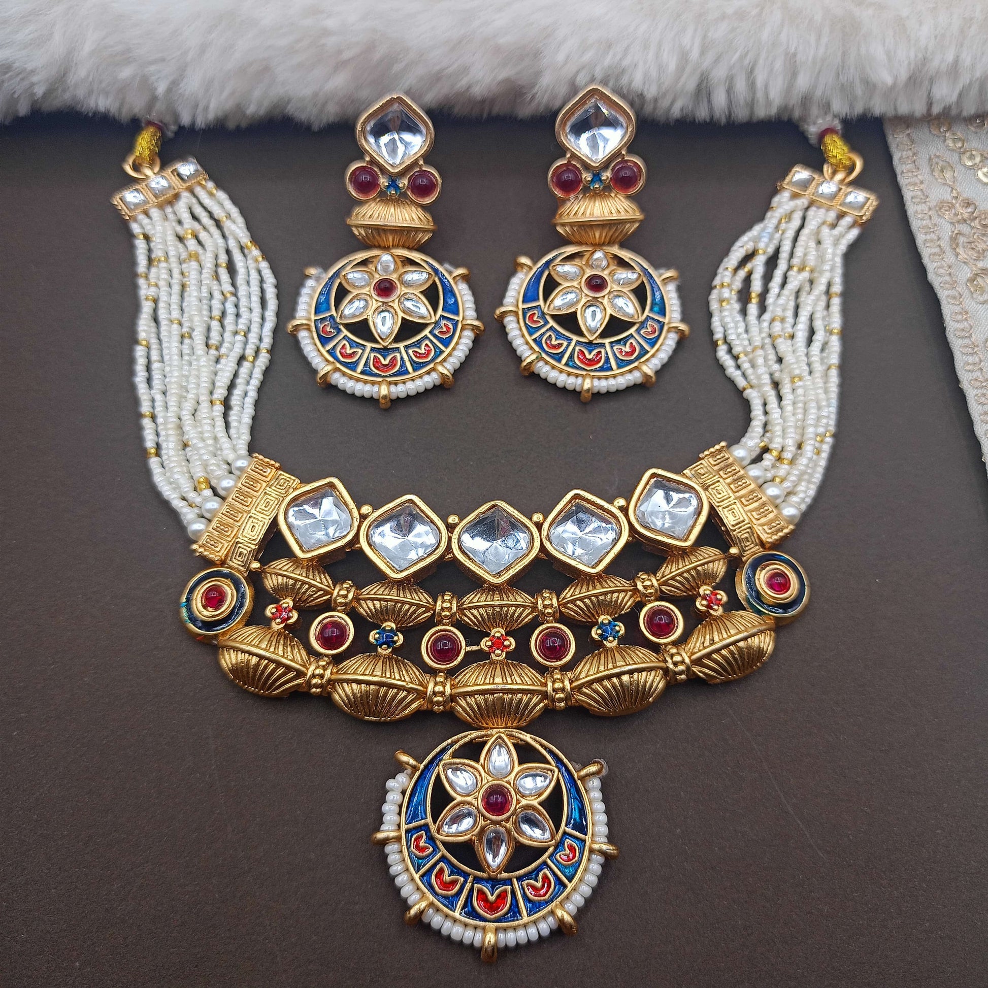 Ornate gold necklace with colorful gemstones on a dark surface