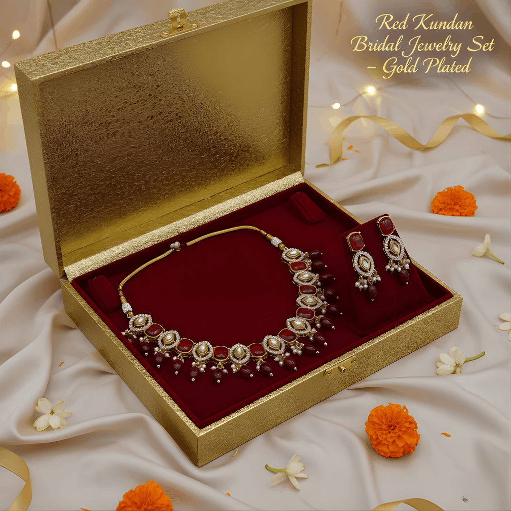 Gold-plated Kundan bridal jewelry set in an open box with decorative flowers on a soft fabric background.