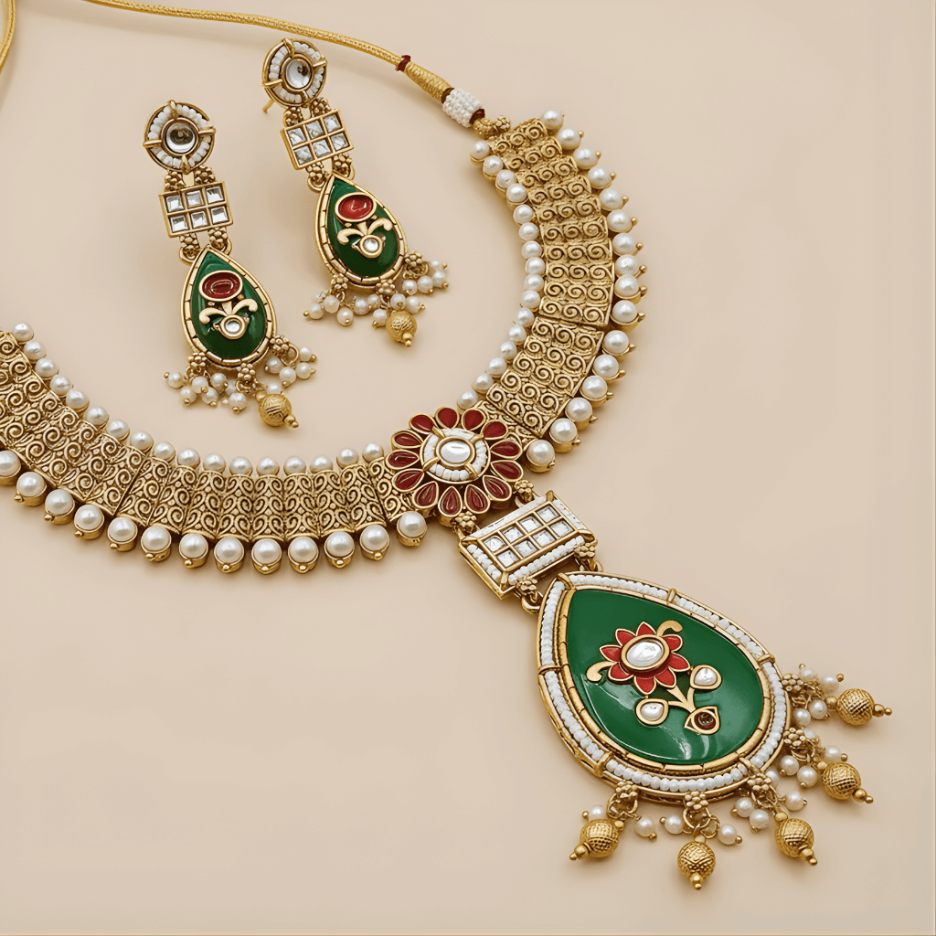 Ornate gold necklace with green and red accents on a beige background