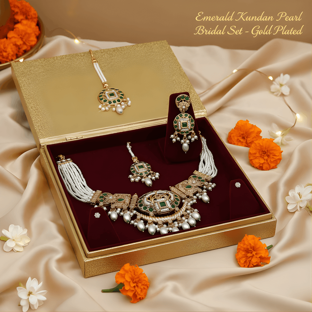 Gold-plated jewelry set with necklace and earrings in a decorative box, surrounded by flowers.