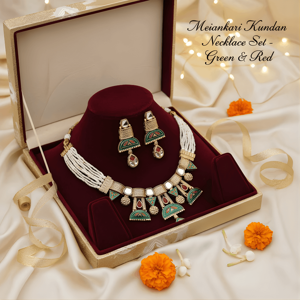 Meenakari Kundan necklace set with green and red design in a jewelry box on a soft fabric background.