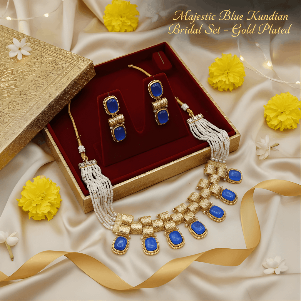 Gold and blue jewelry set with necklace and earrings on a decorative fabric background.