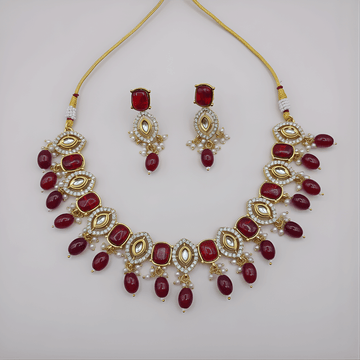 Jewelry set with necklace and earrings featuring red stones on a light gray background