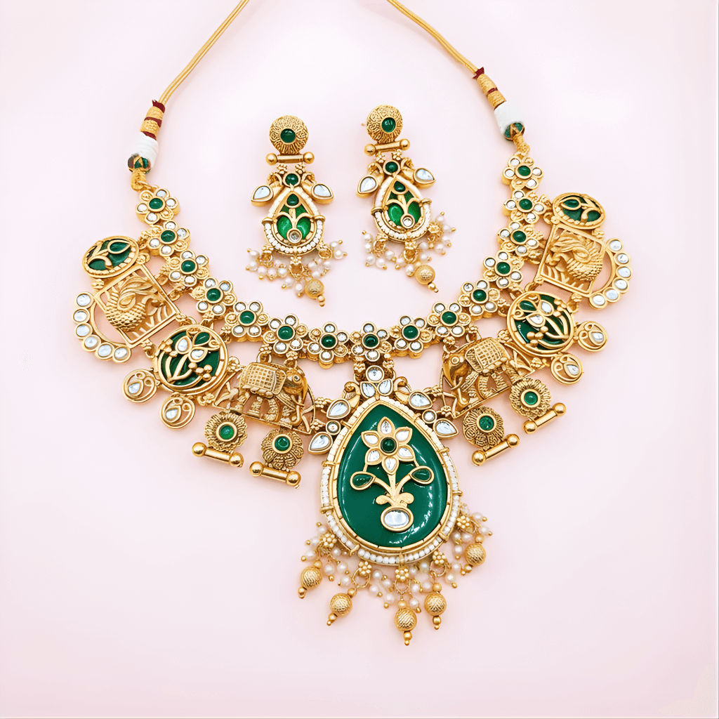 Gold and green jewelry set on a light pink background