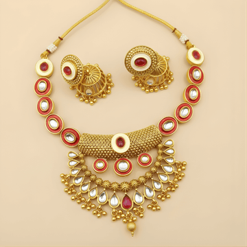 Gold jewelry set with necklace, earrings, and bangles on a beige background
