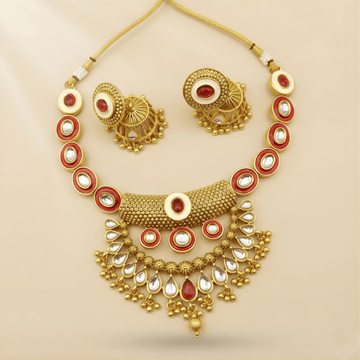 Gold necklace with red and white stones on a beige background