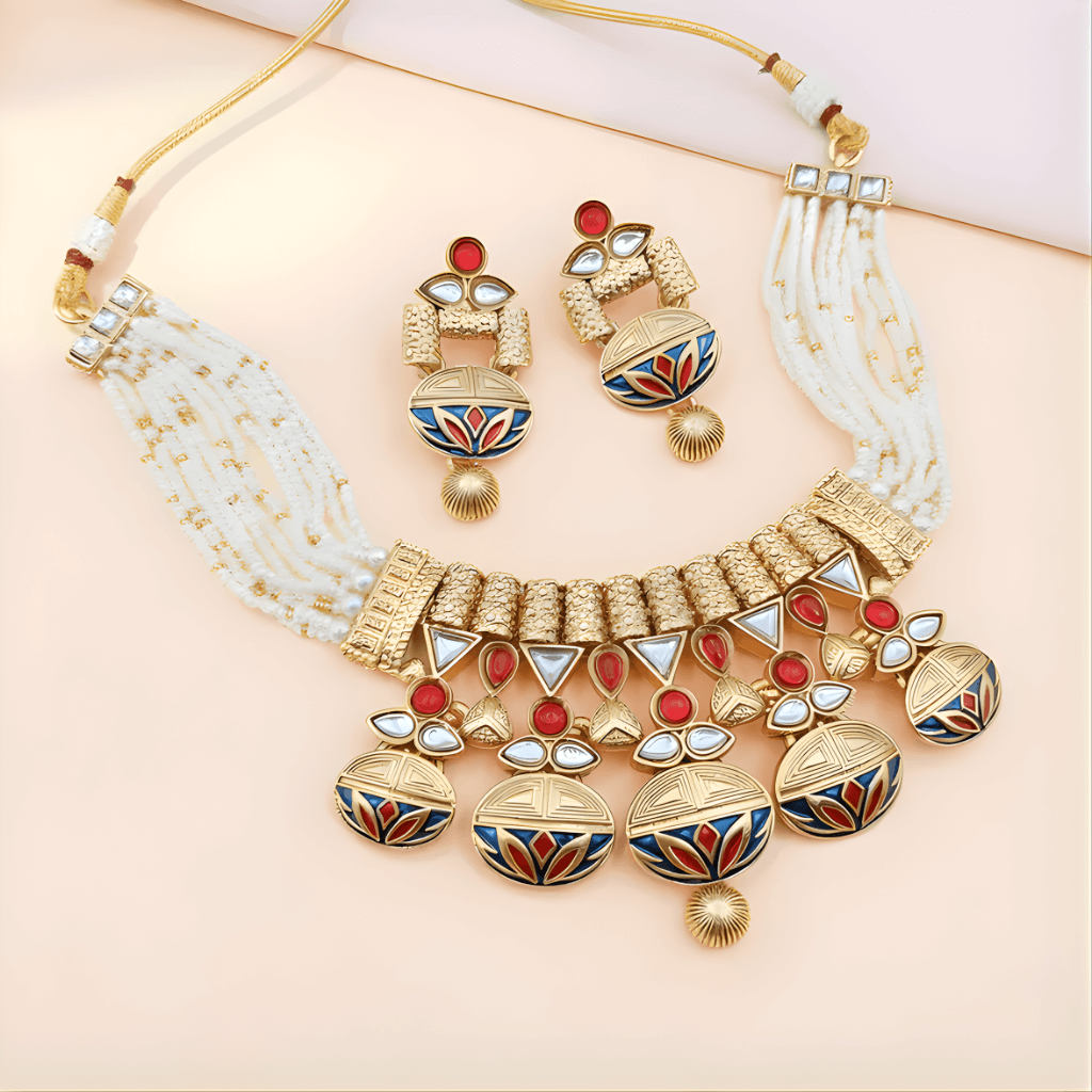 Ornate gold necklace with red and blue accents on a light pink background