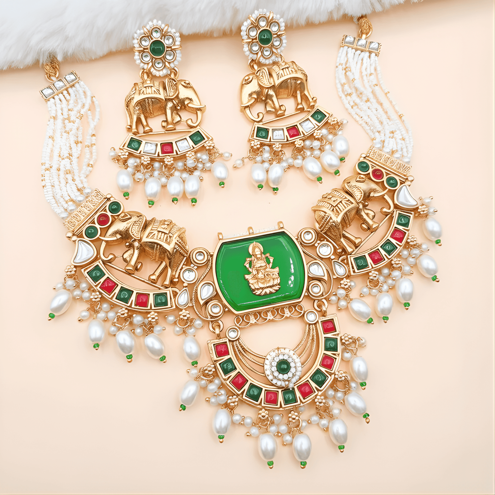 Ornate gold necklace with green gemstone and pearl accents on a beige background